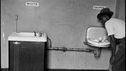 Un hombre bebe en una fuente de agua separada para negros, en Wilmington (Carolina del Norte) en 1950.