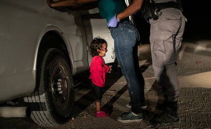 La niña Yana, de Honduras, llora mientras su madre, Sandra Sánchez, es cacheada por un policía estadounidense de fronteras en McAllen (Texas).