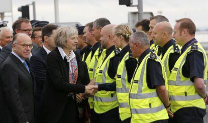 La ministra de Interior británica, Theresa May, saluda a los agentes de policía franceses y británicos durante su visita a las plataformas de embarque del Eurotunnel, el 20 de agosto de 2015.