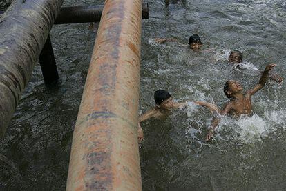 Foto de archivo en la que ve a varios niños que juegan junto a una de las tuberías de Chevron en un río de la província de Sucumbios (Ecuador).