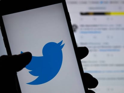 El logo de Twitter, en un teléfono móvil frente a una pantalla con la red social.