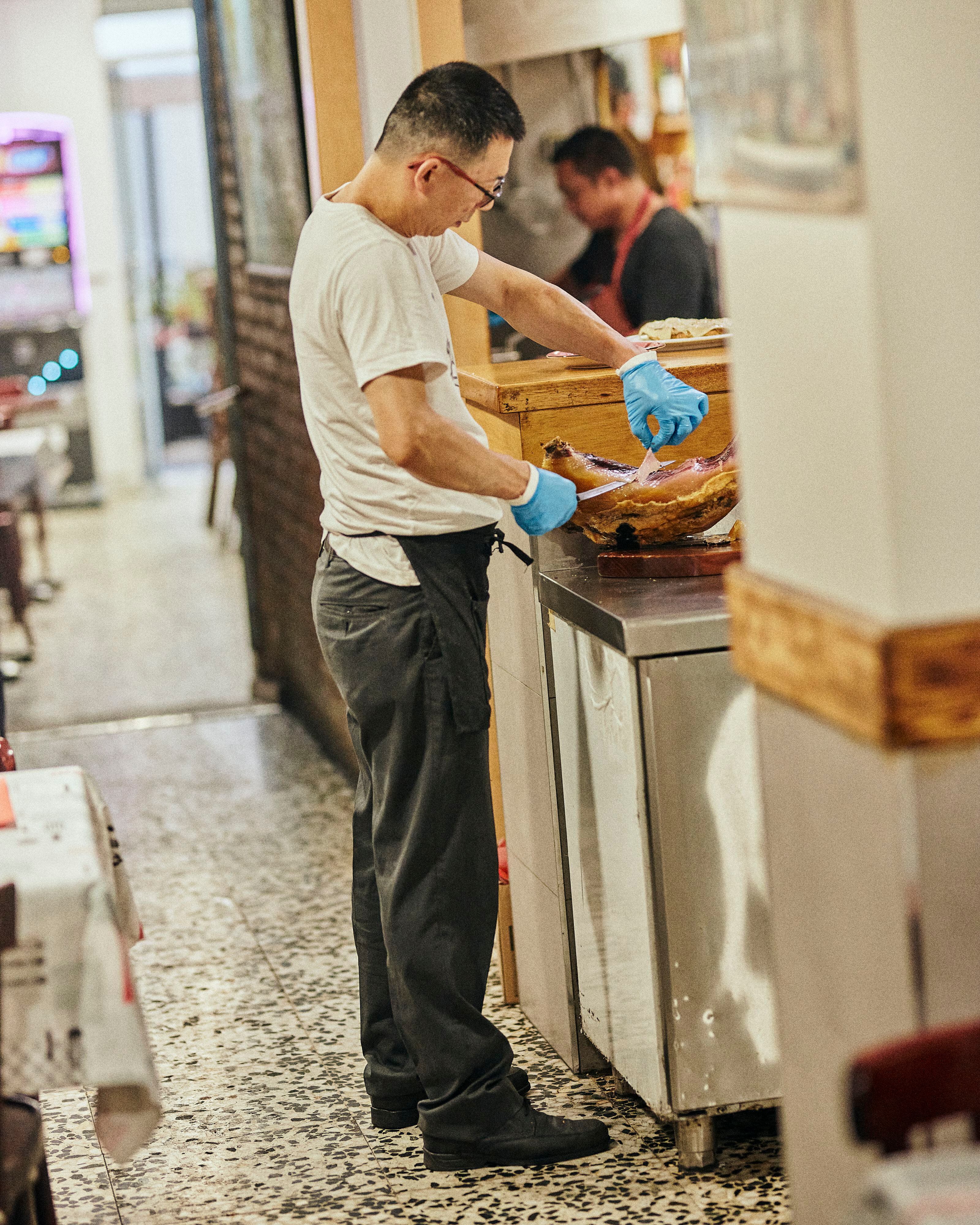  Axín corta con maestría uno de los productos favoritos de sus clientes, jamón ibérico, en Casa Axín. 