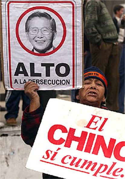Una seguidora de Alberto Fujimori muestra varias pancartas de apoyo al ex presidente peruano