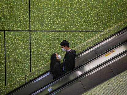 Una pareja vive su amor en tiempos ce coronovirus en un centro comercial de Hong Kong.