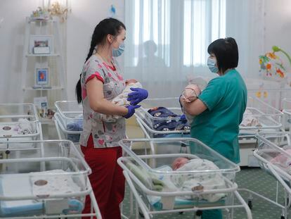Dos enfermeras con bebés nacidos de vientres de alquiler, en mayo de 2020 en Kiev.