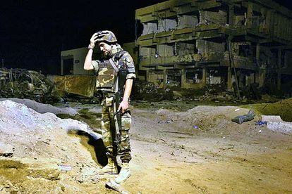 Un militar italiano, ante la base destrozada por el ataque del terrorista suicida Belgacem Bellil.