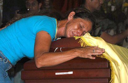 BOG205. CALI (COLOMBIA), 27/06/05.- Un familiar del soldado colombiano Gersón Pazmino Garzón llora sobre su ataúd, hoy 27 de junio, durante el sepelio de cinco de los 22 soldados muertos en una emboscada de las Fuerzas Revolucionarias de Colombia (FARC) en el departamento de Putumayo. Al ataque sobrevivieron 8 militares. EFE/Carlos Durán Araújo