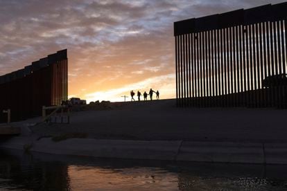 Una familia de migrantes brasileños camina por la frontera entre México y EE UU en junio de 2021.