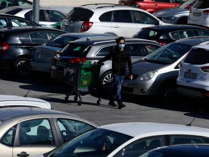 Un hombre lleva una mascarilla en el aparcamiento de un centro comercial en Rivas Vaciamadrid.