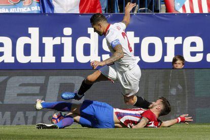 El jugador del Sevilla Vitolo disputa un balón con el centrocampista del Atlético de Madrid Saúl Ñíguez, en el suelo.