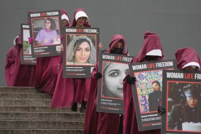 Un grupo de activistas, ataviadas con el hábito de 'El cuento de la criada', protestan en Londres. Con el lema de 'Mujeres, Vida, Libertad', cada una de ellas porta el retrato de una mujer asesinada en Irán. 