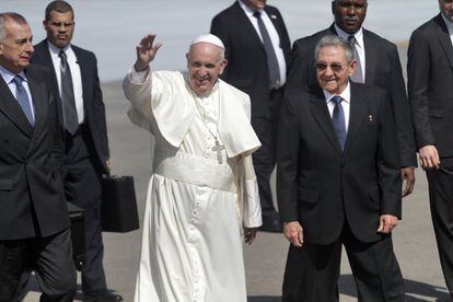 El Papa Francisco saluda a la prensa mientras camina sobre la pista junto al presidente de Cuba, Raúl Castro, a su llegada a la isla, el 12 de febrero de 2016, en La Habana, Cuba.