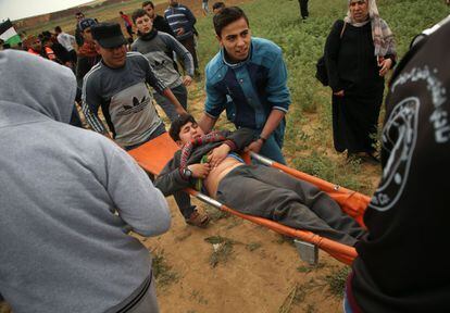 "Dos sospechosos se acercaron durante la madrugada [del viernes] a la valla de separación en el sur de la Franja de Gaza en actitud sospechosa. Como respuesta, un tanque del Ejército disparó contra ellos", uno de los cuales murió, declaró a EFE un portavoz del Ejército israelí. En la imagen, un palestino es trasladado después de ser herido durante una manifestación cerca de la frontera con Israel, el 30 de marzo.