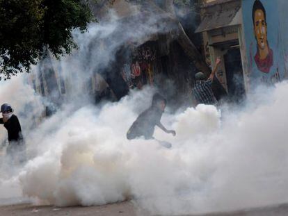 Manifestantes egipcios se enfrentan a la polic&iacute;a junto a la plaza de Tahrir entre el humo de los gases lacrim&oacute;genos. 