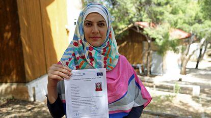 La siria Rawaa muestra su pasaporte para refugiados.