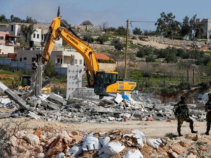 Soldados israelíes vigilan la demolición de un edificio palestino, el lunes en Bani Naim (Cisjordania).