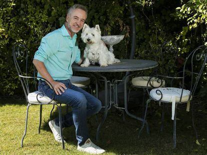 El actor Carlos Hipólito, junto a su perra Trudi en el jardín de su casa, en Madrid.