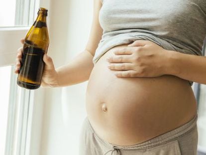 Una dona embarassada, amb una cervesa a la mà.