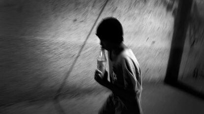 Una joven pasea por la calle inhalando pegamento en la capital de Honduras.