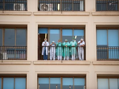 Personal sanitario del Hospital Regional de Málaga agradece desde un balcón los aplausos de la ciudadanía.