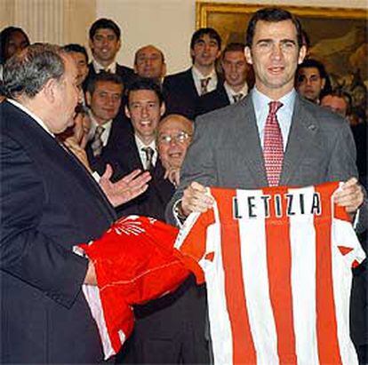 El Príncipe recibe de manos de Jesús Gil una camiseta del Atlético con el nombre de su prometida.