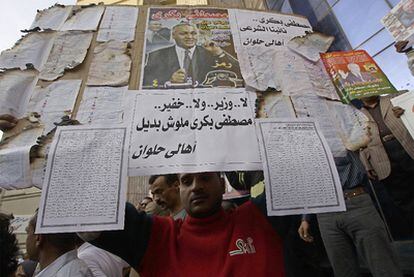 Un hombre muestra papeletas quemadas y otros documentos como prueba del fraude en la primera ronda de las elecciones legislativas egipcias, el pasado 28 de noviembre.