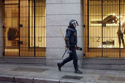 Un policía, armado con un mazo y unas tenazas, se dirige hacia el hotel Madrid, dentro de la operación de desalojo del hotel, ocupado desde el 15 de octubre.