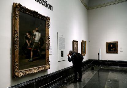 Un visitante consulta al cartela que acompaña al cuadro de Goya 'La fragua'.