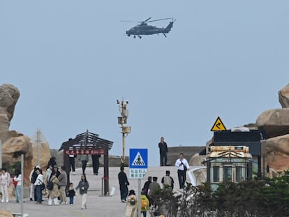 Un helicóptero chino sobrevuela el estrecho de Formosa, cerca de unos turistas en la isla china de Pingtan, este viernes.