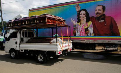 Un camión con féretros pasa por delante de un cartel de la pareja presidencial en Masaya, Nicaragua, el 2 de noviembre