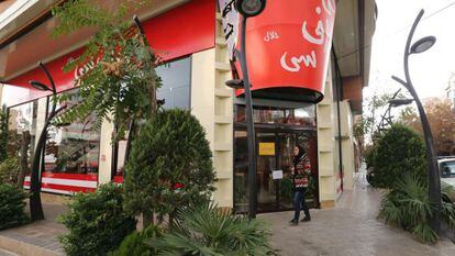 Una mujer camina frente a la puerta del ‘fast food’ con los símbolos del Kentucky Fried Chicken en Teherán, el 3 de noviembre de 2015.