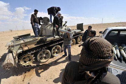 Milicianos rebeldes descargan proyectiles de un tanque de las tropas de Gadafi.
