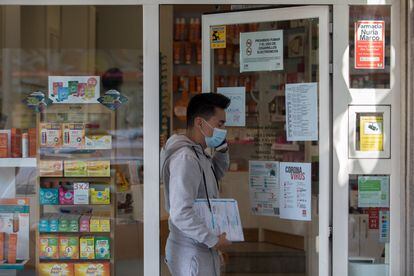 Un joven sale de una farmacia que anuncia en su fachada que tiene mascarillas en Madrid.