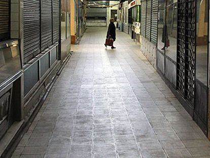 Una mujer camina por el mercado municipal de Bami, en el barrio de Ventas, que el Ayuntamiento prevé vender.