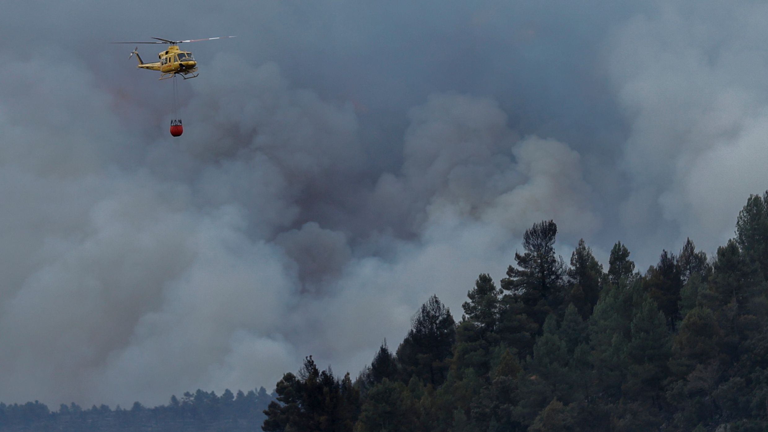 Un helicóptero sobrevolaba el jueves una columna de humo en el incendio forestal en Villanueva de Viver.