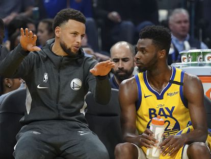 Andrew Wiggins, a la derecha, habla con Stephen Curry durante un partido entre Golden State y Nueva Orelans en febrero de 2020.