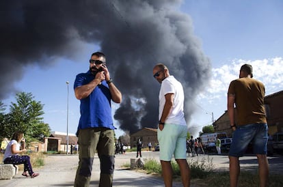 Vecinos de la localidad Chiloeches (Guadalajara) observan el incendio declarado en una planta de reciclaje de productos industriales.