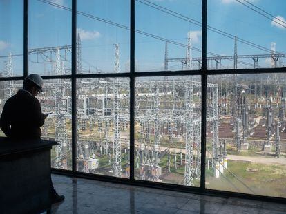Un trabajador mira un dispositivo móvil frente a la subestación eléctrica de la Comisión Federal de Electricidad en Acolman, Estado de México.