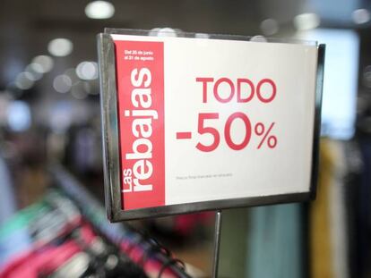 Cartel de rebajas en un perchero con camisas en la tienda de El Corte Inglés en Preciados, Madrid (España). 