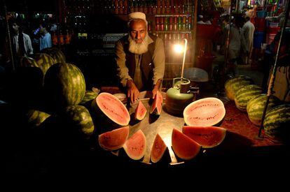 Un vendedor ambulante de Afganistán prepara sandías para los clientes en su puesto al borde de la carretera de Jalalabad.
