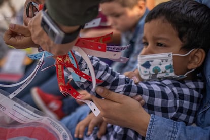 Un oficial fronterizo de Texas le quita un brazalete de estatus migratorio a Santiago, quien viajó con su madre desde Honduras para solicitar asilo.