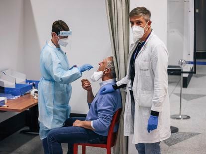 Un sanitario toma la muestra para hacer una prueba diagnóstica a un pasajero procedente de China en el aeropuerto de Malpensa, en Milán, este jueves.