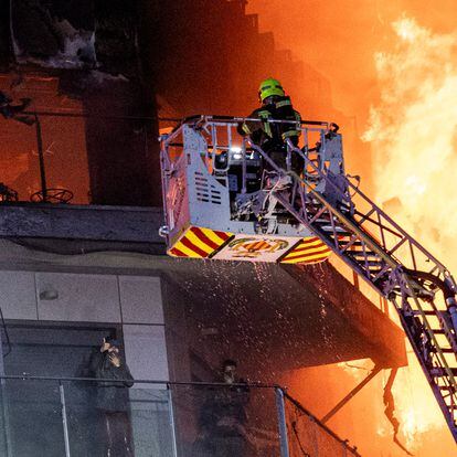 Los bomberos rescataban el jueves a una pareja que pedía ayuda desde un balcón del edificio incendiado en Valencia.