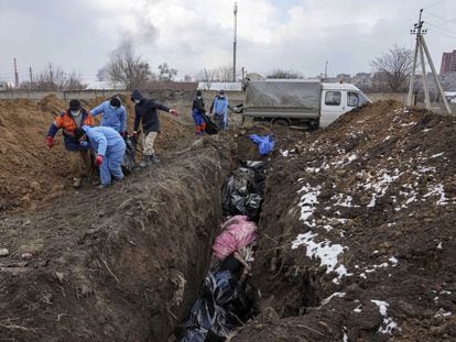 Entierro de cadáveres en una fosa común a las afueras de Mariupol, el 9 de marzo.
