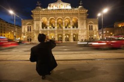 Un turista fotografiando el edificio de la ópera de Viena.