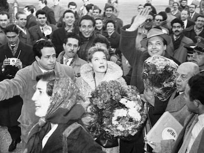 Enrique Herreros hijo, con el brazo, abre camino entre el gentío a Romy Schneider el 15 de enero de 1957 a su llegada al aeropuerto de Barajas para promocionar 'Sissi'. A la derecha, con la caja de la distribuidora Dipenfa, Enrique Herreros padre.