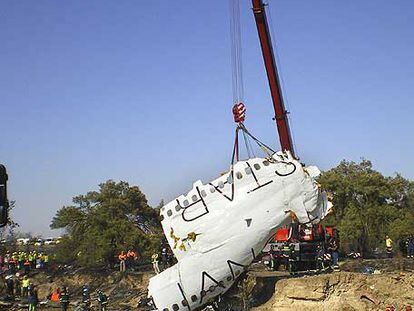 Una grúa levanta el pasado jueves lo poco que quedó del avión siniestrado en el aeropuerto de Barajas.