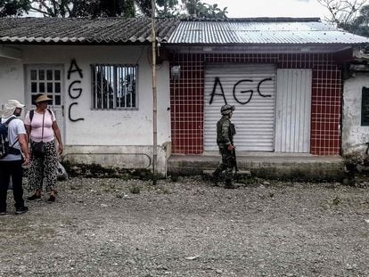 Un soldado del ejército colombiano junto a un graffiti del Clan del Golfo o "AGC" (Autodefensas Gaitanistas de Colombia", un grupo paramilitar, en La colonia, Bajo Calima, Colombia, el 18 de mayo de 2022.