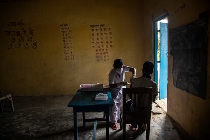 Un trabajador de salud administra la vacuna Covishield a un vecino en una escuela en la aldea de Kaurhagi en el distrito de Morigaon de Assam, India, el viernes 6 de agosto de 2021.