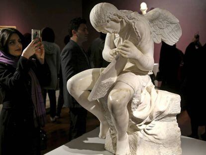 Una mujer junto a la escultura &#039;Funerary Genius&#039; en la exposici&oacute;n &#039;El Louvre en Teher&aacute;n&#039;, inaugurada el 5 de marz&oacute; en Teher&aacute;n. 
